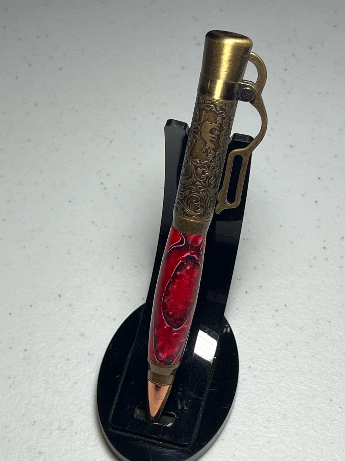 Lever action pen in antique brass with red grasshopper pattern barrel